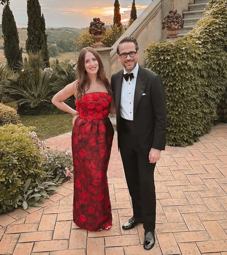 Black tuxedo with peak lapels, pique bib shirt, black bow tie and patent loafers, worn in a sunset garden