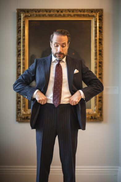 Navy chalk stripe flannel suit with white shirt, burgundy dotted silk tie and white pocket square, worn by a model