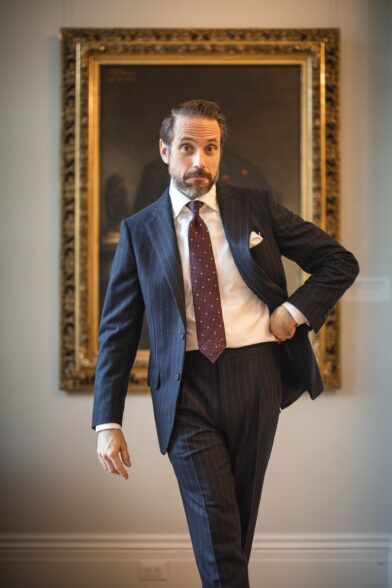 Navy chalk stripe flannel suit with white shirt, burgundy dotted tie and white pocket square, worn by a model