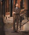 Brown donegal tweed suit with blue shirt, striped tie and brown oxfords, worn by a model on a city street