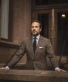 Brown donegal tweed suit jacket with light blue shirt, navy tie and white pocket square, worn by a model on brownstone steps