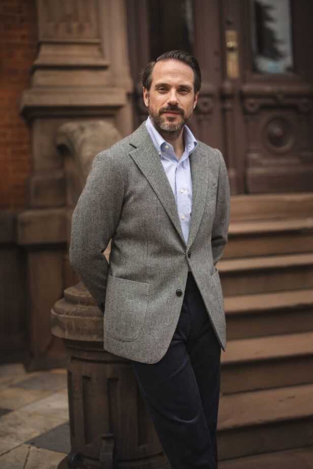Grey herringbone tweed sport coat with patch pockets, blue shirt and navy corduroy trousers, worn by a model