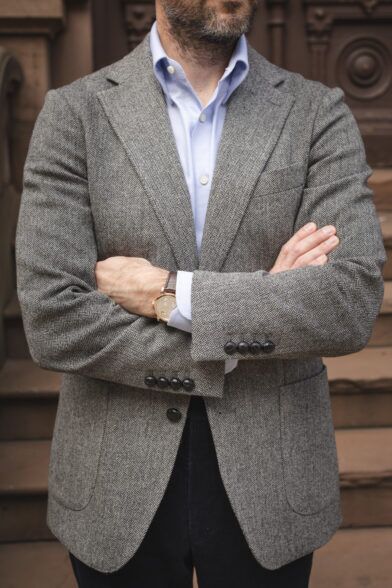 Grey herringbone tweed sport coat with patch pockets, light blue shirt and navy corduroy trousers, worn by a model