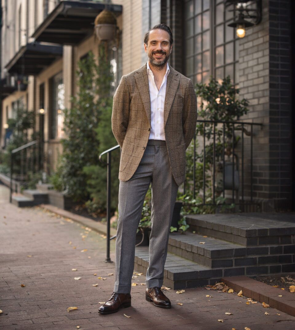 Brown glen plaid wool sport coat with white shirt and grey flannel trousers, on a city sidewalk