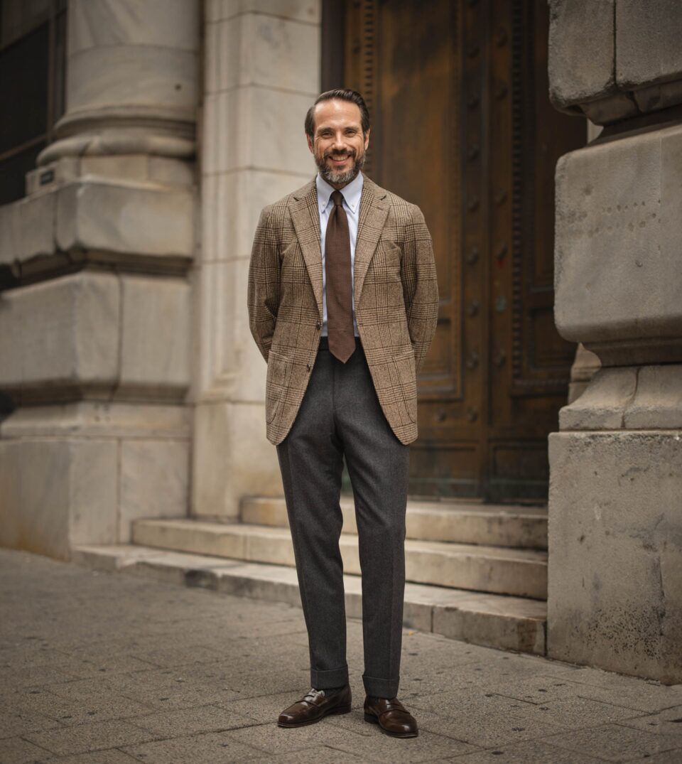 Brown glen plaid wool sport coat with blue shirt, brown grenadine tie and charcoal flannel trousers, worn by a model