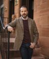 Brown glen plaid sport coat with burgundy crewneck sweater, white shirt and dark jeans, worn by a model on brownstone steps