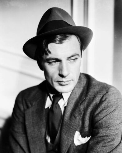 Felt fedora worn with a tweed sport coat, dark tie and white pocket square in a black and white portrait