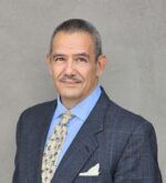 Charcoal windowpane sport coat with blue shirt, cream floral silk tie and white pocket square, worn by a man