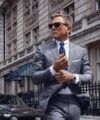 Grey glen check suit with white shirt, navy tie and white pocket square, worn on a city street