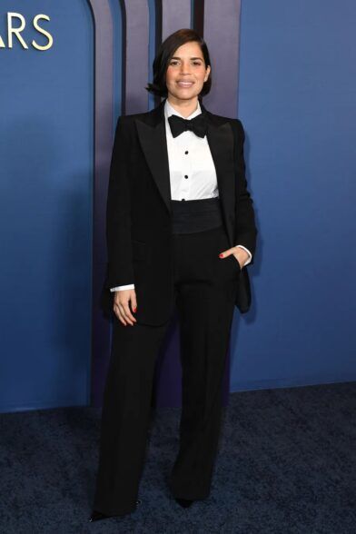 Black peak lapel tuxedo with white pique bib shirt, black bow tie and cummerbund, worn on a red carpet