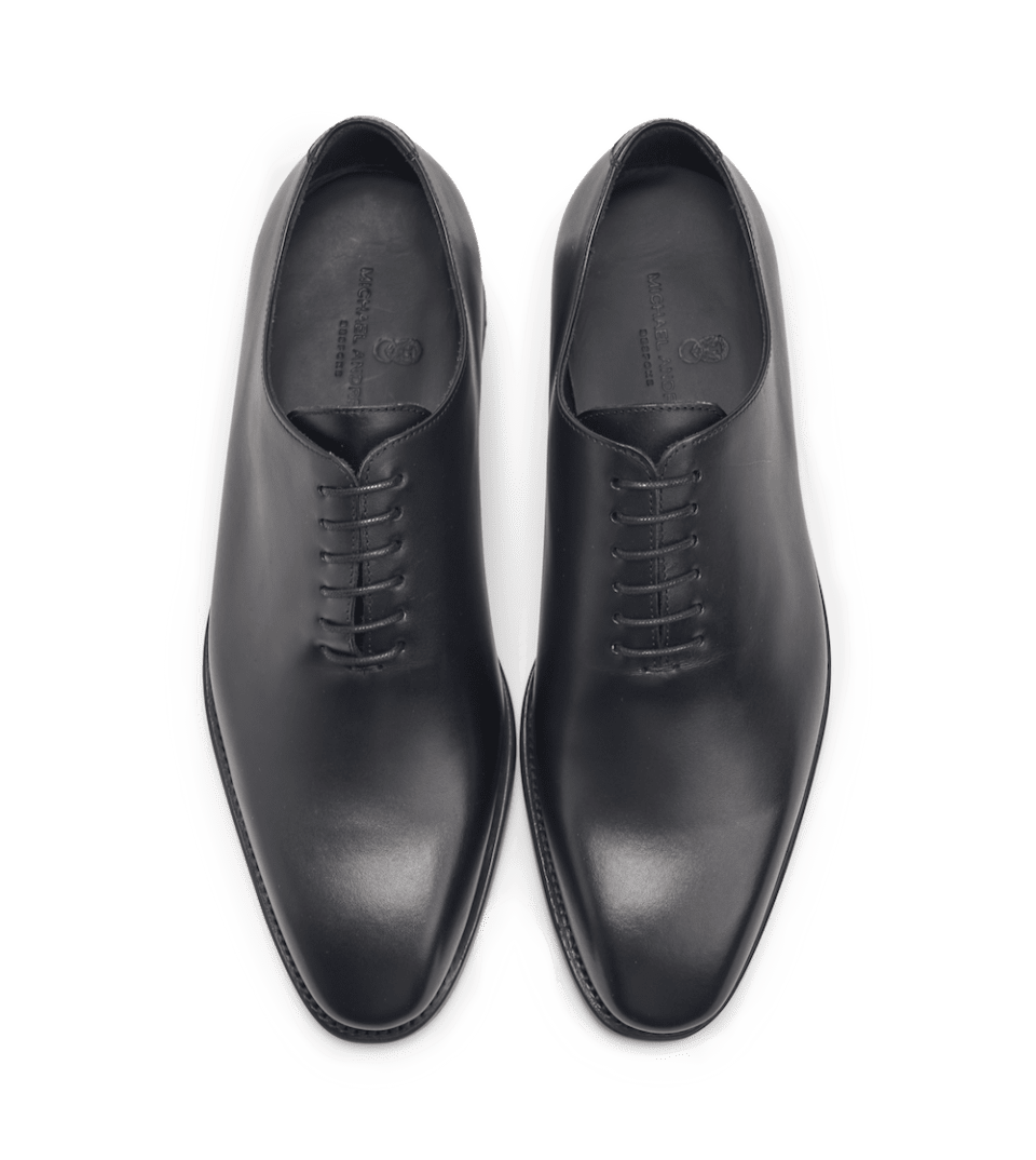 Black box calf leather wholecut lace-up oxfords, overhead flat lay of both shoes