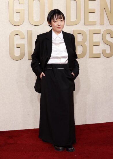 Black oversized blazer with white satin shirt and long black skirt, worn on a red carpet