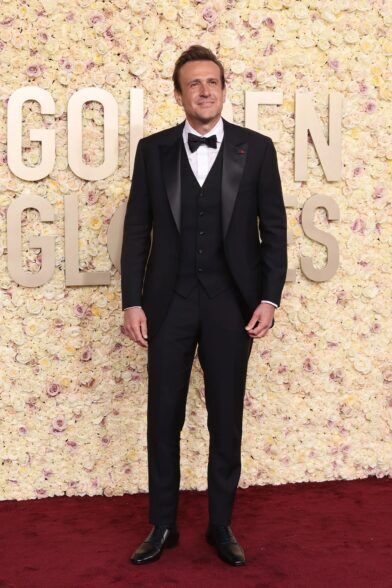 Black three-piece peak lapel tuxedo with waistcoat, white shirt and black bow tie, worn on a red carpet