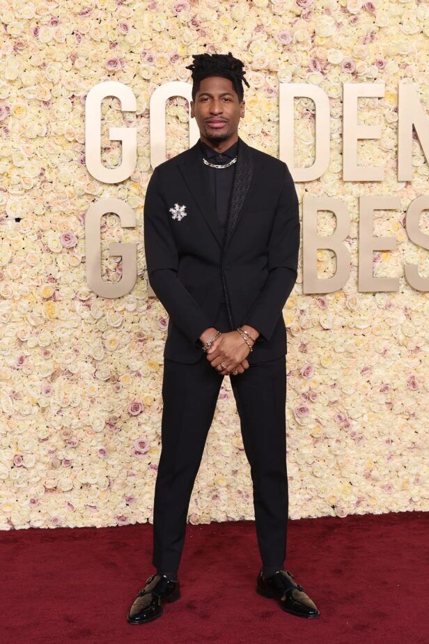 Black shawl collar tuxedo with black shirt, crystal brooch and patent monk strap shoes, worn on a red carpet
