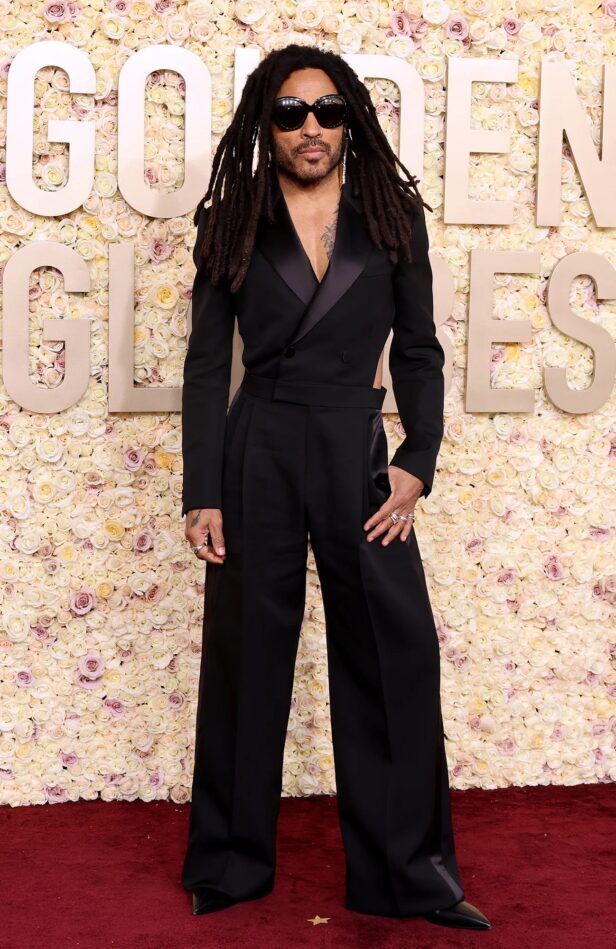 Black cropped double-breasted tuxedo jacket with satin peak lapels and wide-leg trousers, worn on a red carpet