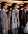 Light grey suit, grey chalk stripe suit with fringed scarf and brown tweed jacket, worn by three men