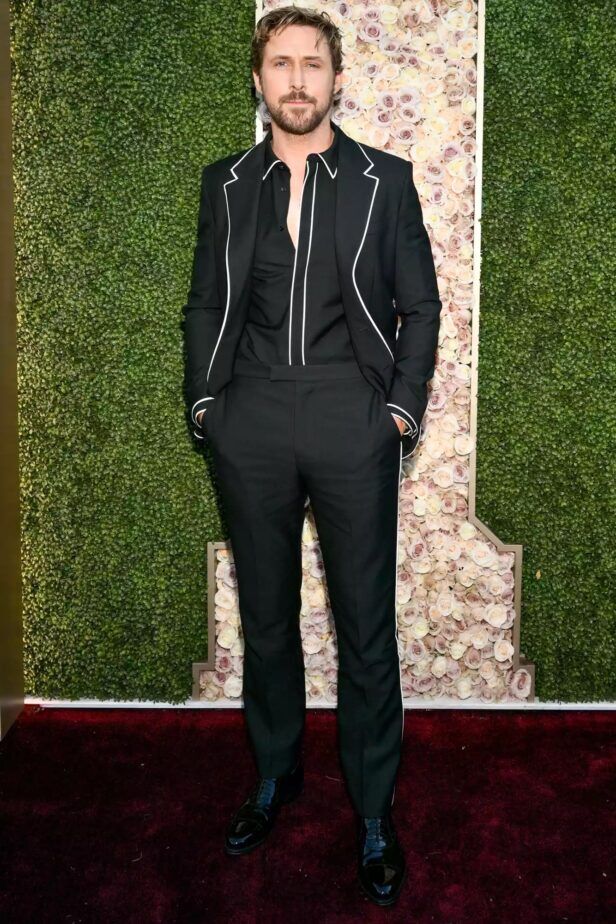 Black suit with white contrast piping, black shirt and patent lace-ups, worn by a man on a red carpet