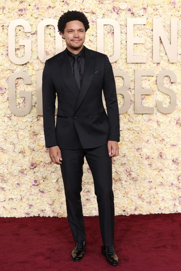 Black double-breasted peak lapel tuxedo with black shirt, tie and patent shoes, worn on a red carpet