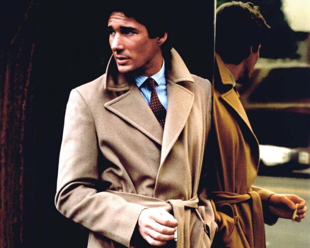 Camel wool belted overcoat with blue striped shirt and brown dotted tie, worn by a man in a street scene