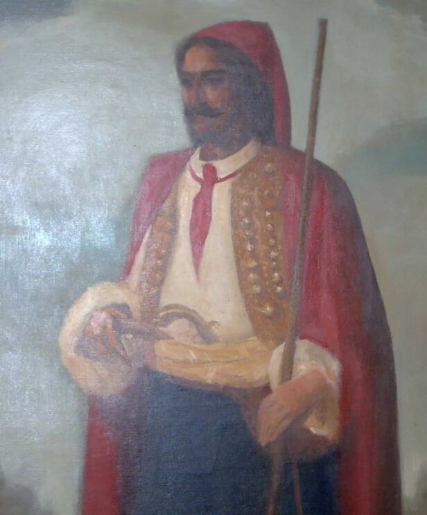 Red silk cravat knotted over a white shirt with gold-embroidered waistcoat and red cloak, in a painted portrait