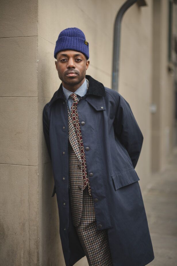 Navy cotton car coat with corduroy collar over a brown houndstooth suit and burgundy tie