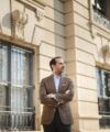 Brown textured wool-silk sport coat with patch pockets and charcoal trousers, worn on a city street