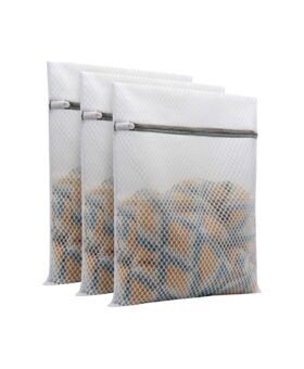 White honeycomb mesh laundry bags with grey zippers, set of three filled with clothing, flat lay