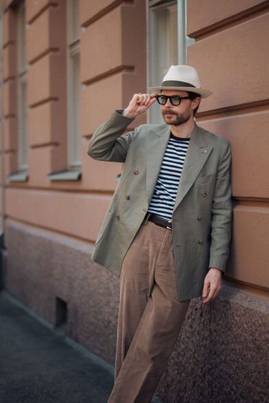 Olive double-breasted sport coat with striped tee, tan corduroy trousers and a straw fedora, worn by a model