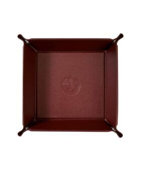 Burgundy leather valet catchall tray with snap corners and embossed crest, overhead view