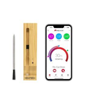 Meater Plus wireless meat thermometer with bamboo charger beside a phone showing the app