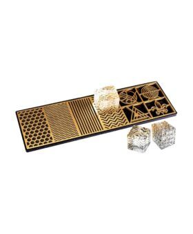 Gold-etched clear ice cube tray with three patterned ice cubes alongside