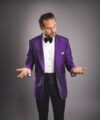 Purple silk dinner jacket with black bow tie and cummerbund, worn by a model