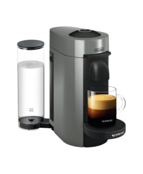 Grey capsule coffee machine with a clear water tank and a filled glass cup