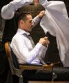 White dress shirt with a houndstooth tie, worn by a seated man at a barber chair