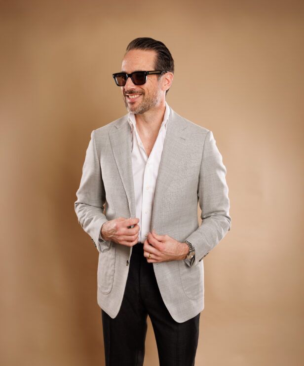 Light grey sport coat with a white shirt and charcoal trousers, worn by a model