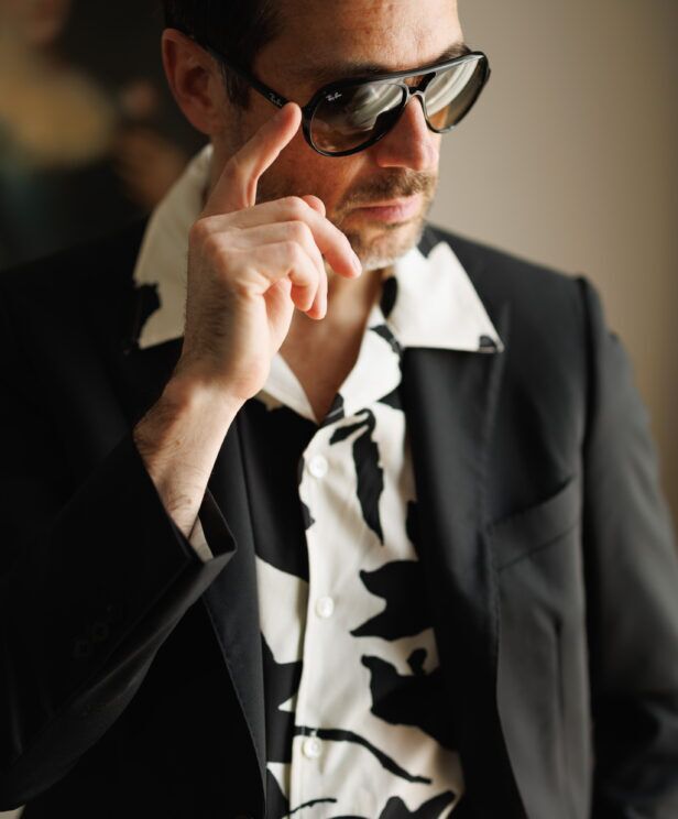 Black and white printed camp shirt under a black suit jacket, a close-up of the collar