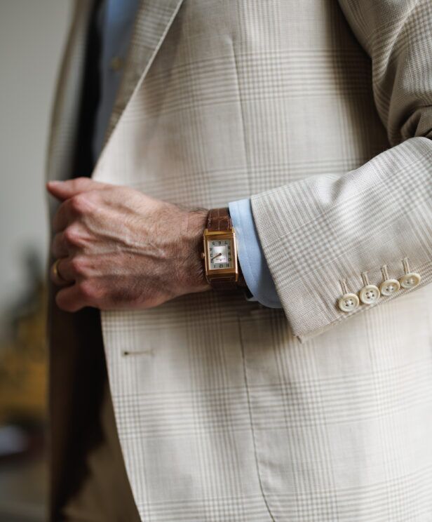 Tan glen plaid blazer with a blue shirt and gold watch, a close-up of the sleeve buttons