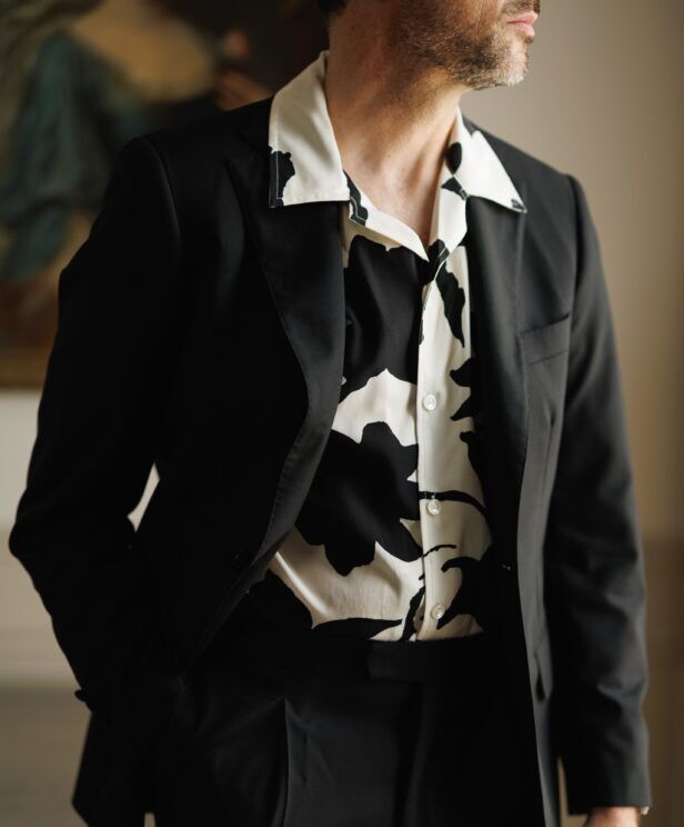 Black suit over a black and white printed camp shirt, a close-up of the open collar