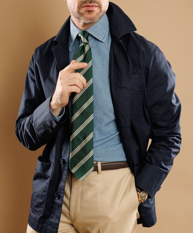Navy chore coat over a chambray shirt with a green striped tie, a close-up of the front