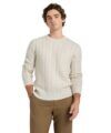 Cream cable knit merino wool crewneck sweater with tan trousers, worn by a model