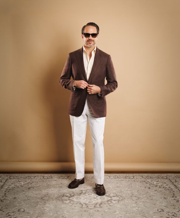 Rust brown hopsack sport coat with cream shirt, white trousers and brown bit loafers, worn by a model