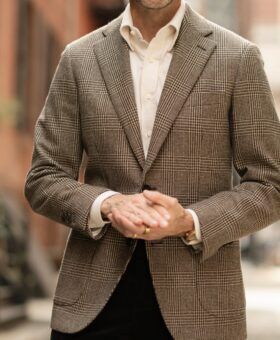 Brown glen check wool sport coat with cream shirt and dark corduroy trousers, worn by a model on a city street